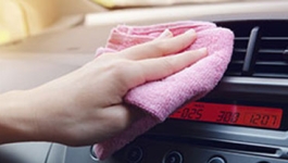 Person wiping off car dashboard